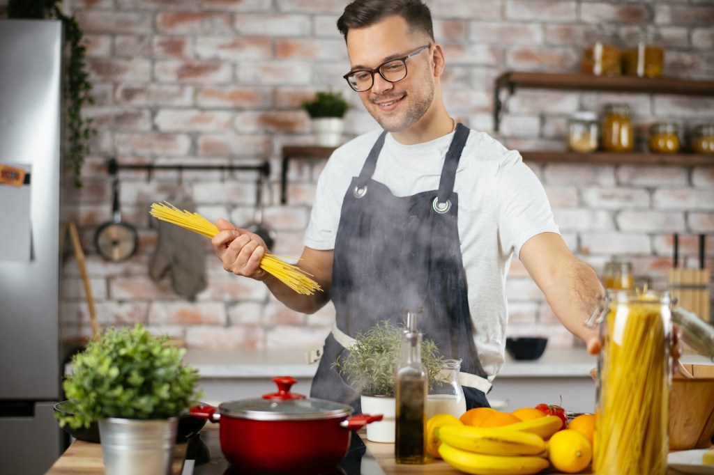 Chef preparing pasta in modern kitchen