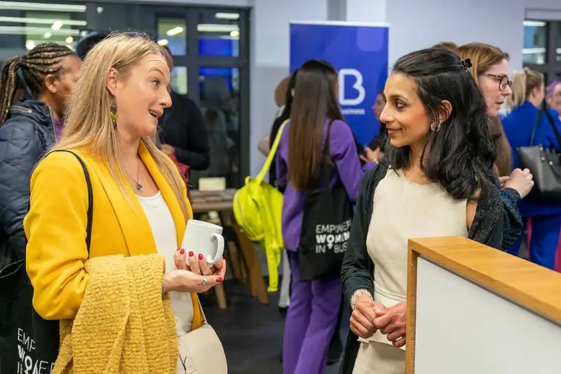 Two women talking at a networking event