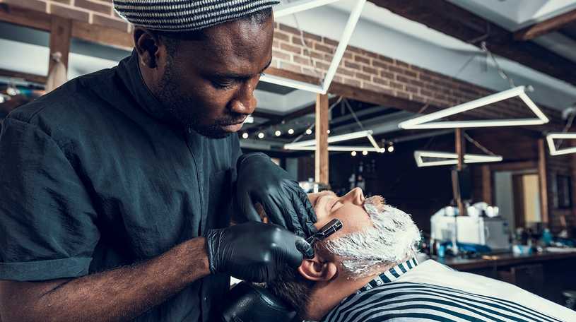 Freelance barber shaving a beard