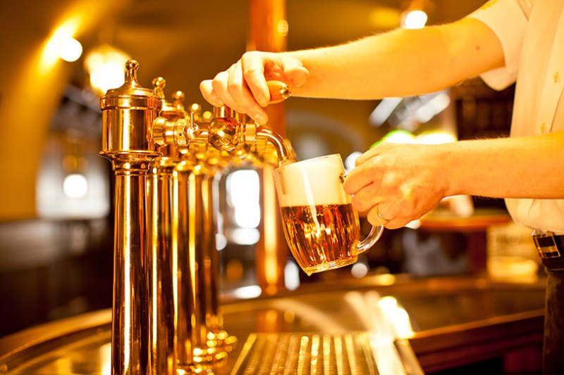 A pub owner pouring a pint