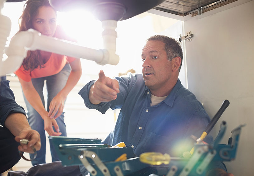 A plumber explains how he will fix a sink to a customer