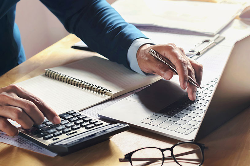 A small business owner doing their accounting on a calculator