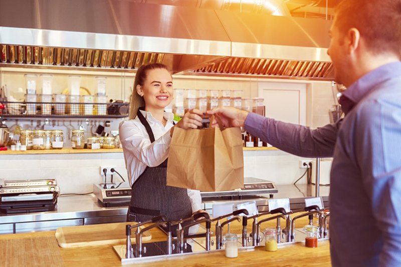 Waitress gives food to customer in a takeaway