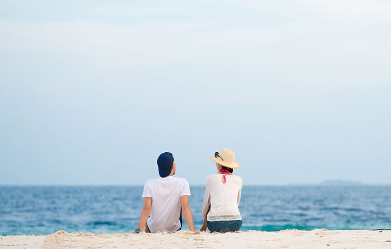 People on a beach on holiday looking out to see