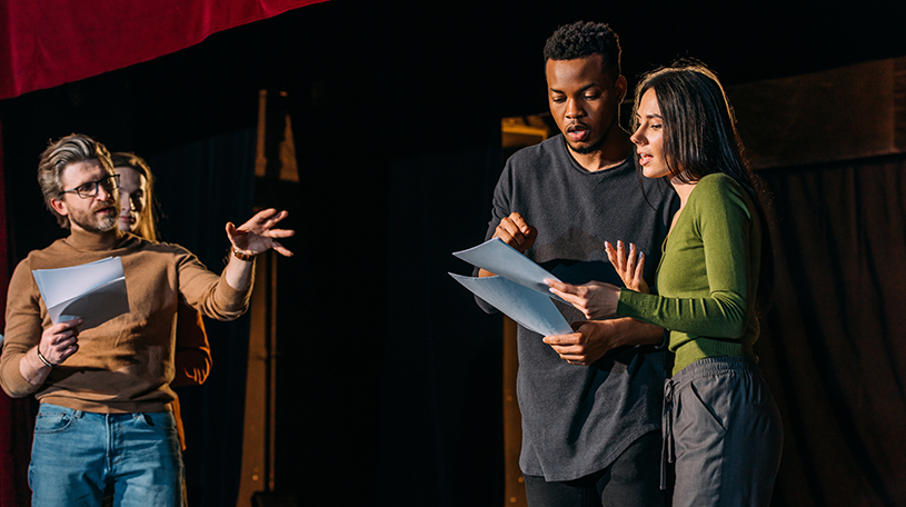 Young theatre group practising lines on a stage