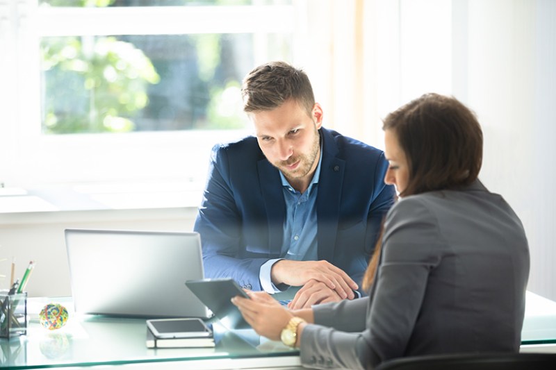 Two business people using digital tablet