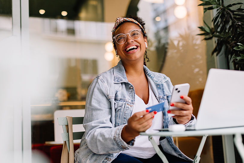 Happy woman online shopping in a café