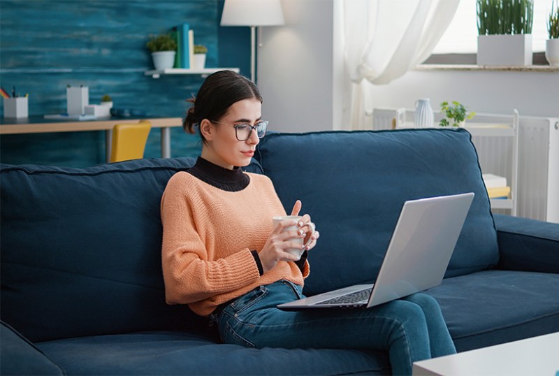 Young business owner reading from a laptop at home