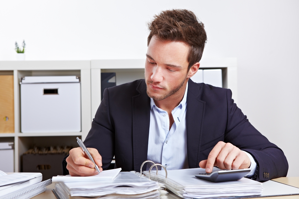 Man in a suit calculating business finances