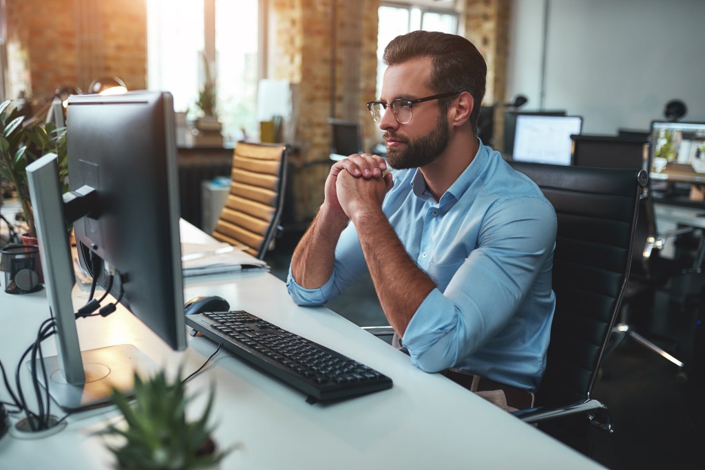 Man in glasses looking at computer