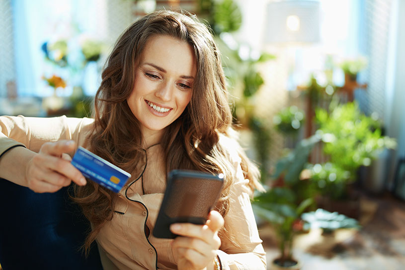 A consumer shopping online, using her credit card to make a purchase on her phone