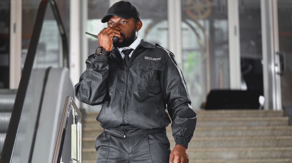 Security guard making call on walkie-talkie