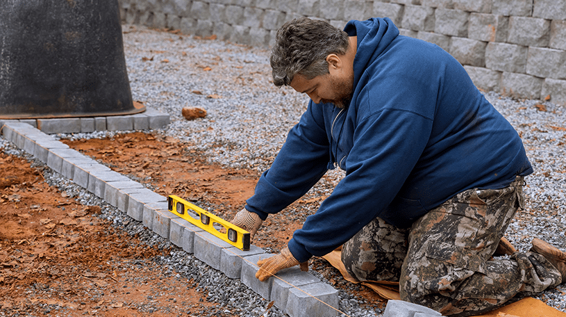 Male worker laying driveway stones