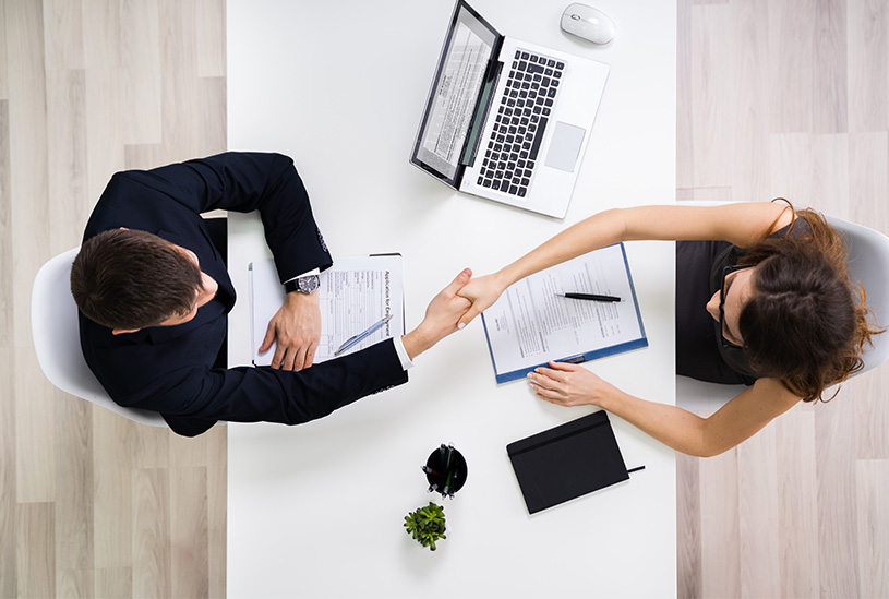 Business owner and prospective employee signing an employment contract