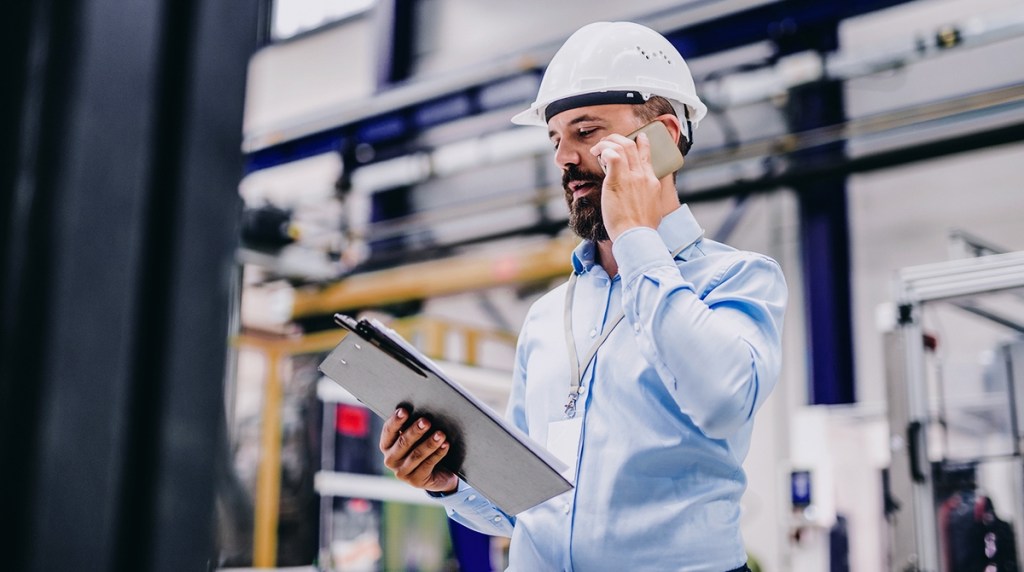 Energy assessor on phone reading from a clipboard