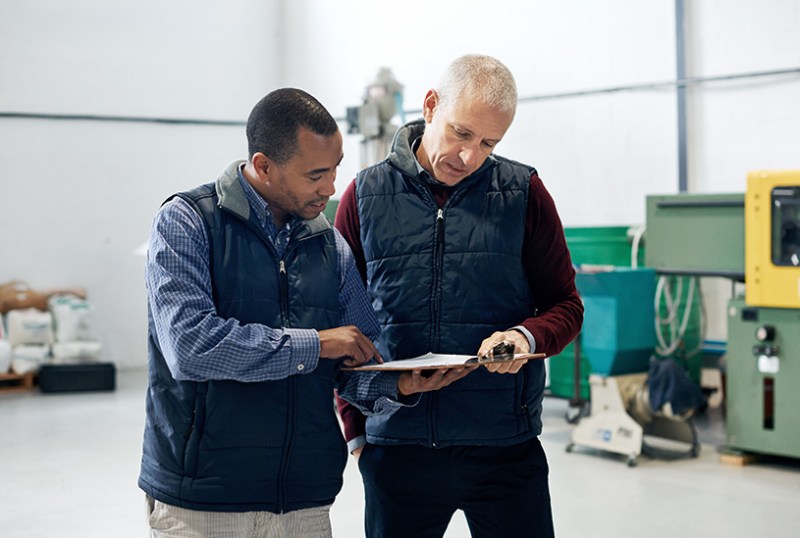 Business owners looking at paperwork in a warehouse