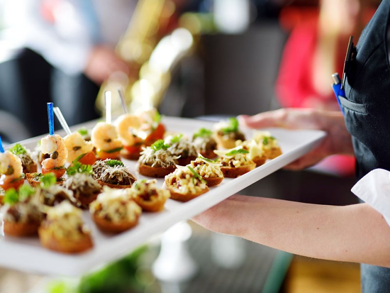 A caterer holding a tray of food