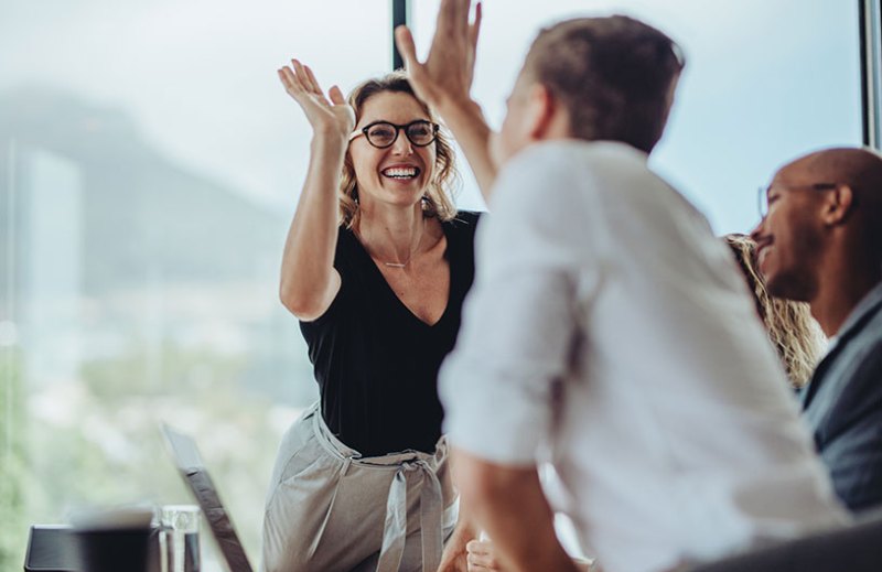 Two people having a high five at work