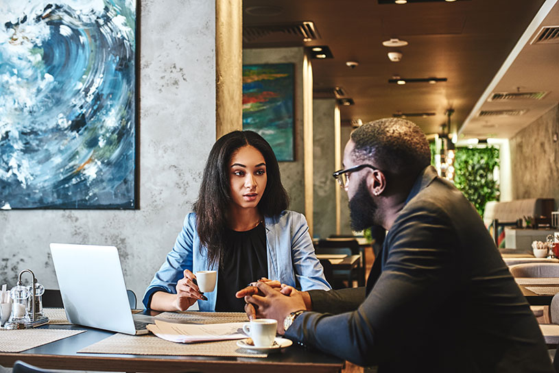 Manager giving feedback to an employee in a coffee shop