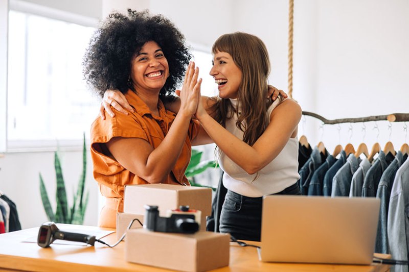 Two women celebrating a clothing shop sale