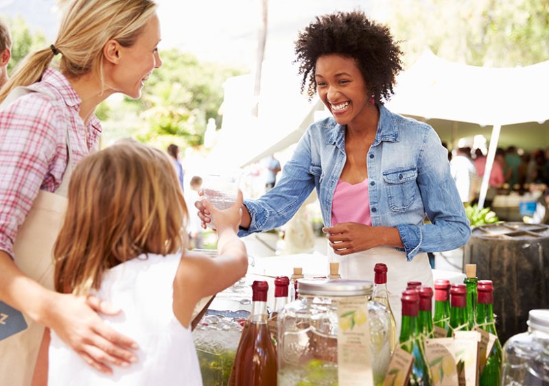 Woman selling soft drinks at a farmers' market