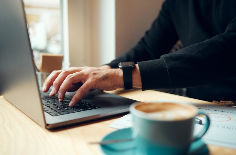 Typing at a laptop in a coffee shop