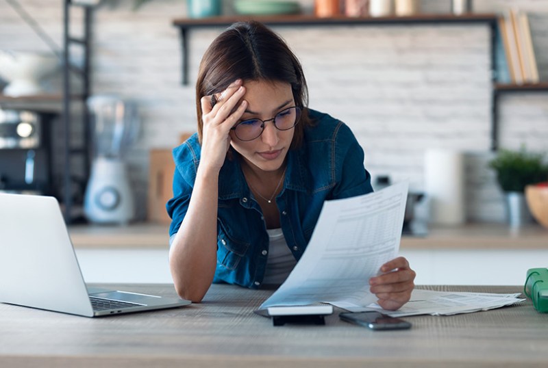 Confused landlord looking at documents and laptop