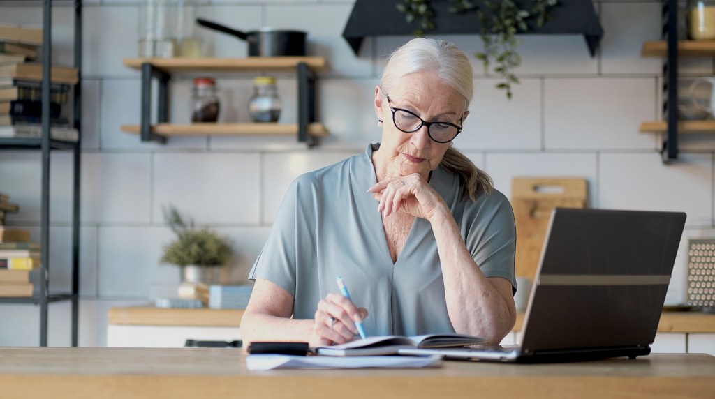 Landlord legal advisor making notes from a computer at a kitchen table