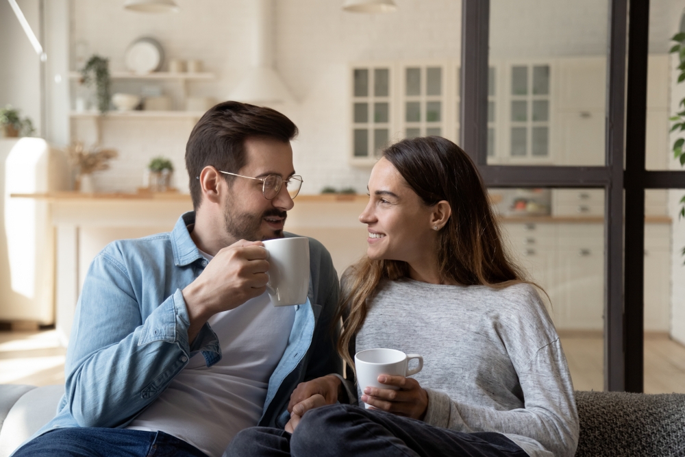 Happy couple enjoys cup of tea on the sofa