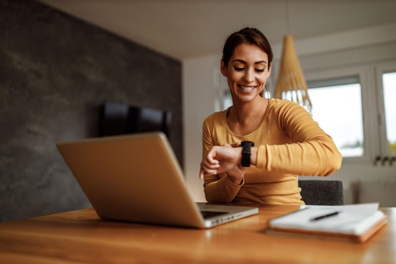 Business woman on laptop looking at the time