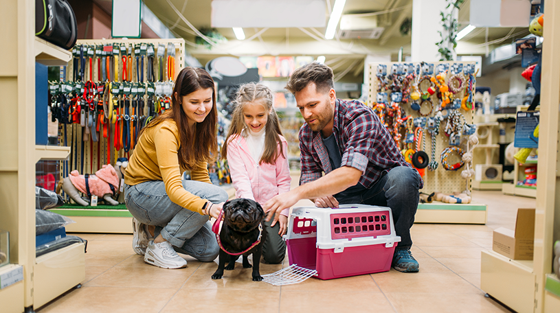 A family petting a dog in a pet store