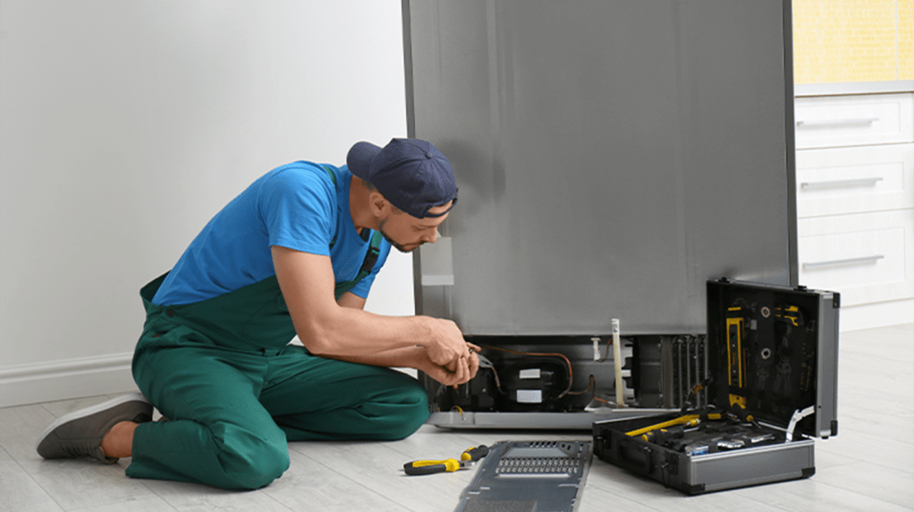 A refrigeration engineer working on a fridge