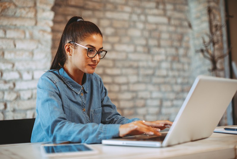 Business woman doing taxes at laptop