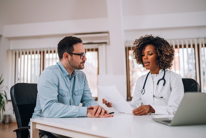 Doctor giving patient a sick note