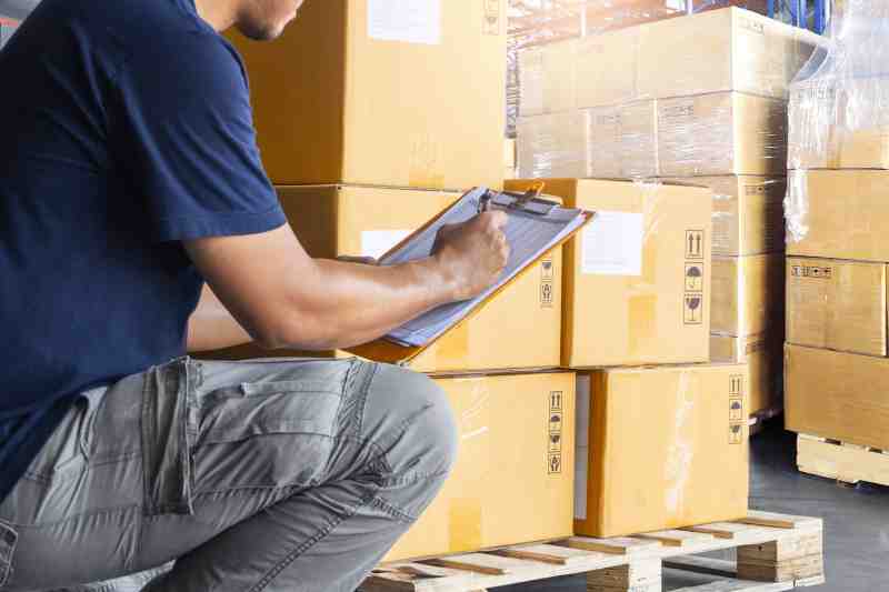 Courier doing inventory in a warehouse