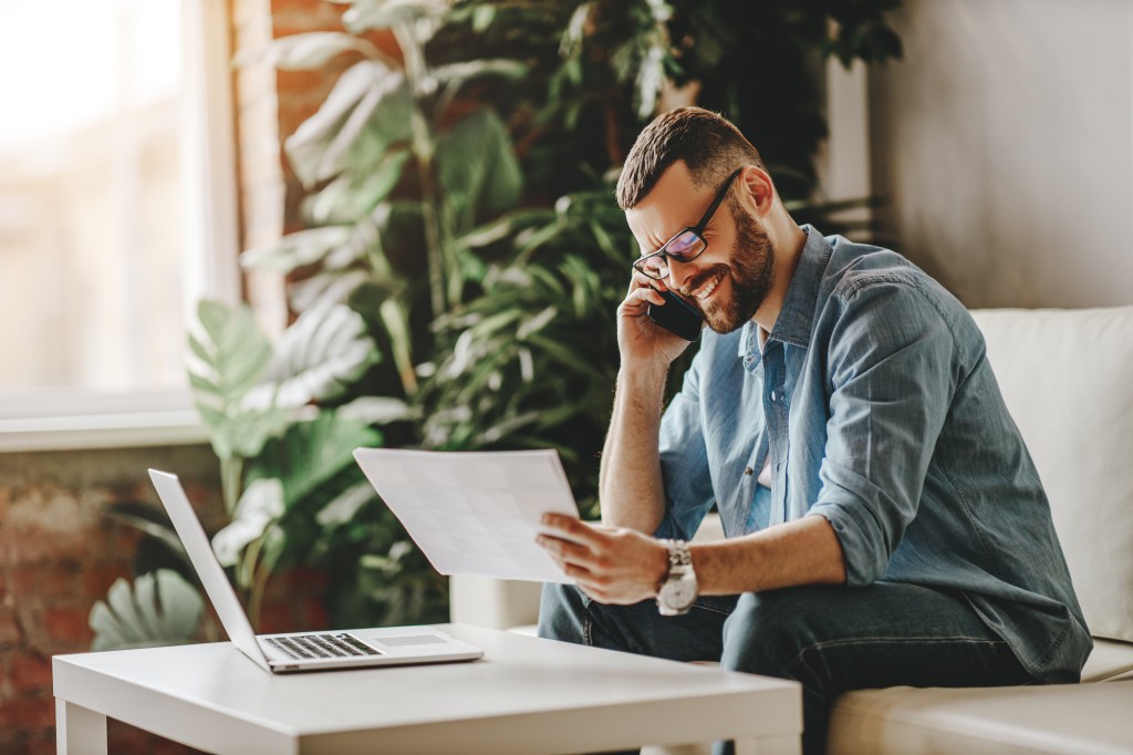 Man on phone looking at paper document