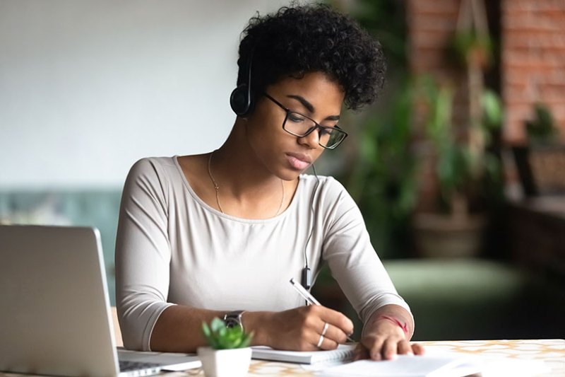 Woman studying and writing notes