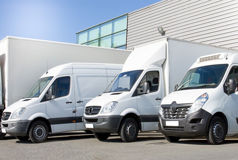 Three different van types parked outside a warehouse.