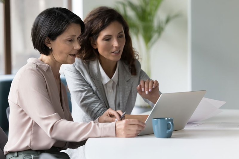 Two women in an office looking at a laptop