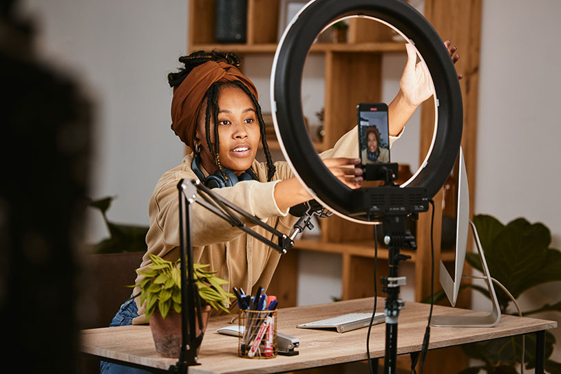 Female business owner sets up a ring light to shoot content on her phone