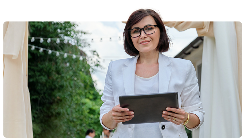 Event organiser stood outside holding a tablet.