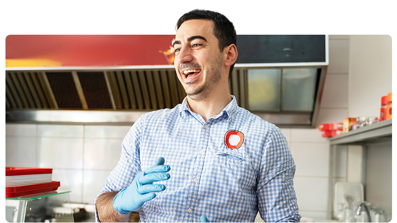 Fish and chip shop owner in a blue shirt and gloves