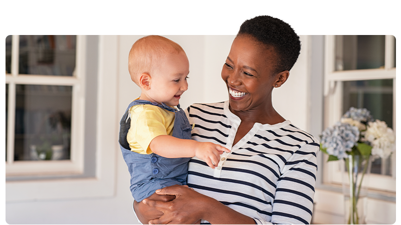 A nanny holding a smiling baby