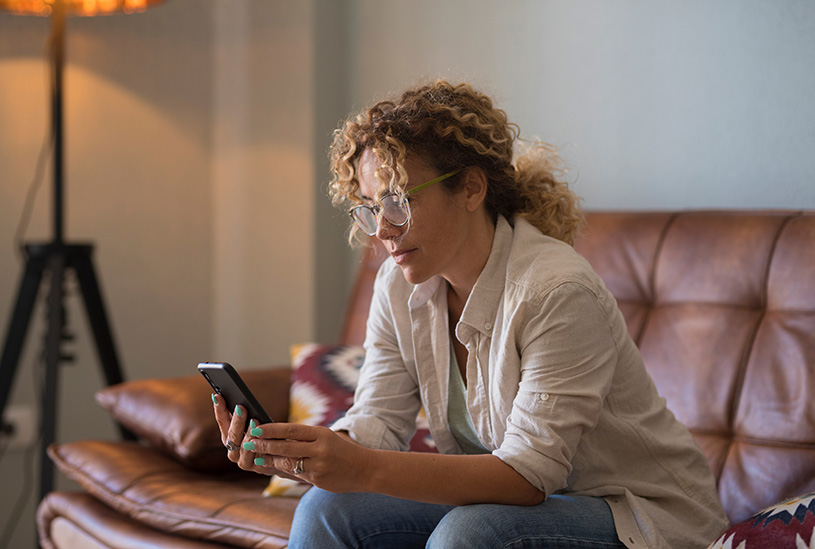 Tenant sitting on the sofa, looking at their phone