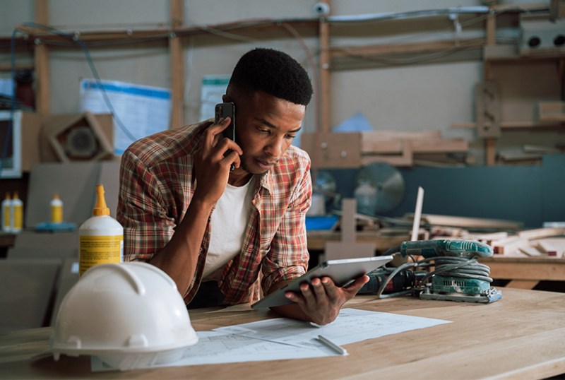 Tradesman working out reverse charge VAT on tablet