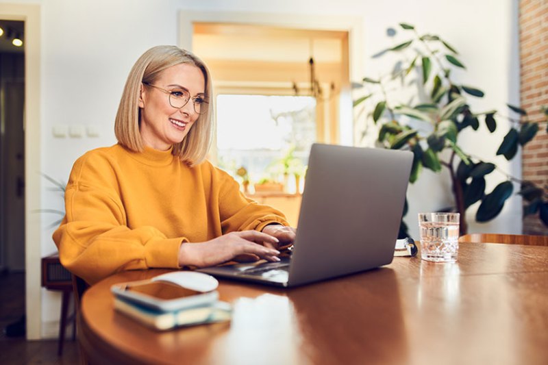 A blonde woman works on on her business laptop