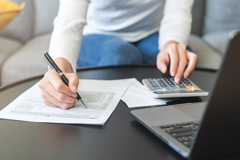 A small business owner using a calculator to prepare for the tax year